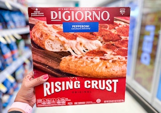 hand holding up box of DiGiorno pizza