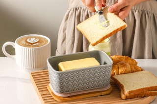 Person using the butter dish to help prepare food