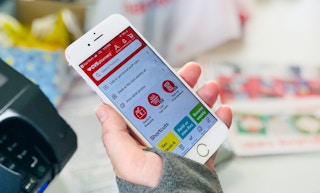 hand holding a smartphone with the CVS app open at checkout