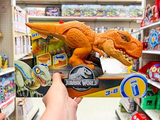 hand holding fisher-price jurassic world t-rex at target