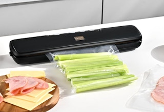 a vacuum sealer machine sealing in celery on a table