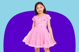 Child wearing a pink Barbie-themed tutu dress