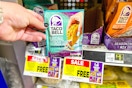 hand holding taco bell seasoning mix in front of dollar general shelf