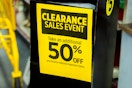 Yellow sign for the Dollar General Clearance Event, showing 50% off previously reduced clearance items.