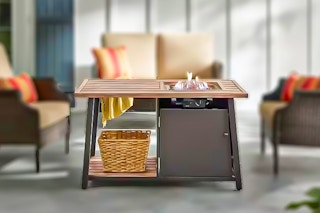 Lifestyle image of Hampton Bay Fire Pit Coffee Table set up outdoor with patio furniture in background