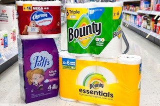 bounty, charmin, and puffs products on the floor in front of a cart