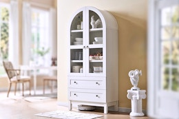 Lifestyle image of a white arched storage cabinet in home setting
