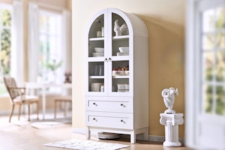 Lifestyle image of a white arched storage cabinet in home setting
