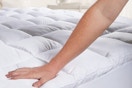 person pushing down on mattress pad