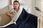 Woman using the Easthome Electric Heated Throw Blanket - Waffle Sherpa 50"x60" in a chair. 
