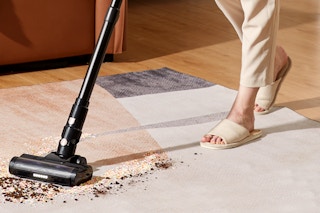 a person using a vacuum cleaner in a living room