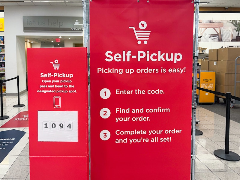 The self-pickup shelf and signs near the customer service desk inside Kohl's.