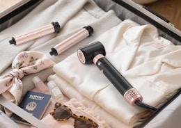 a hair styler in a suitcase with clothes and accessories 