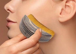 a person using a contour brush on their face 