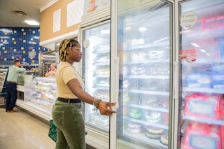 Person opening fridge to look at cakes inside