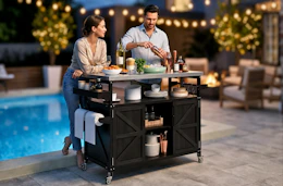 Lifestyle image of 2 people using a rolling grill cart outdoors by a pool (backyard setting)