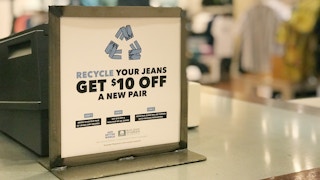 A sign on an American Eagle counter advertising an offer for recycling denim.
