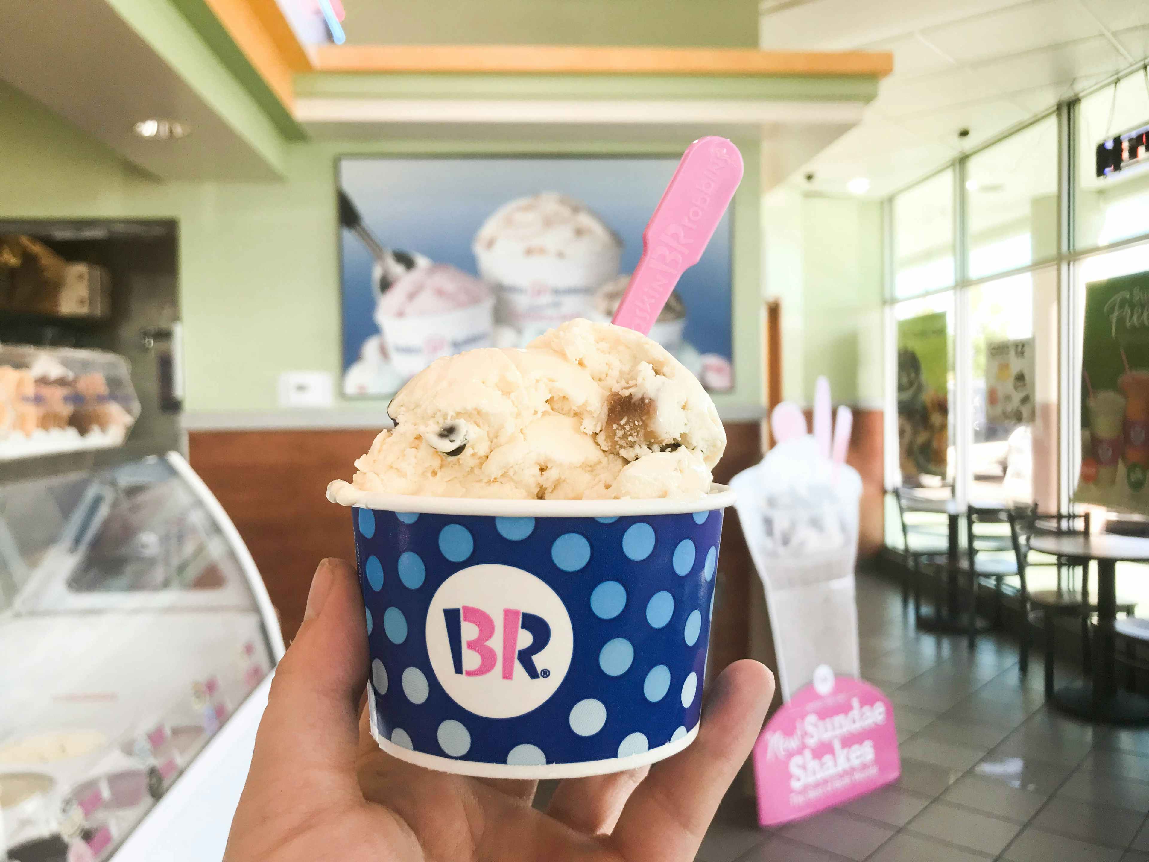 a hand holding up ice cream from baskin robbins 