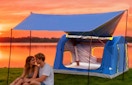 two people sitting under an inflatable tent