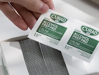 hand holding alcohol pads