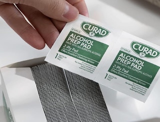 hand holding alcohol pads