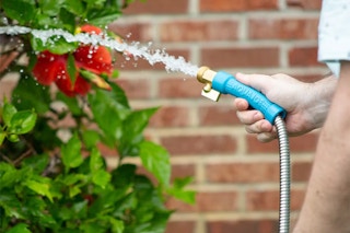 someone using the Aqua Joe Stainless Steel Garden Hose, 25 ft