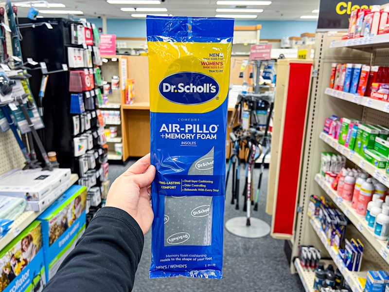 person holding a package of memory foam insoles in an aisle