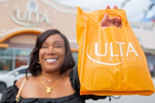 a woman holding an ulta bag outside of an ulta 