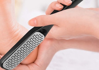 a foot being scrubbed with a foot file