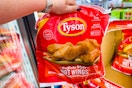 hand holding a bag of tyson chicken wings