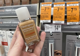 A hand holding a Neutrogena makeup bottle.