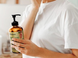 a person holding a pump bottle of castor oil
