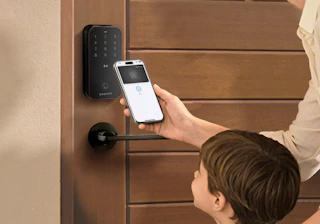 a family unlock their front door with their phone