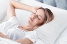 a woman sleeping on queen pillows