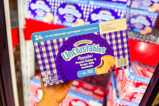 hand holding a box of smucker's uncrustables