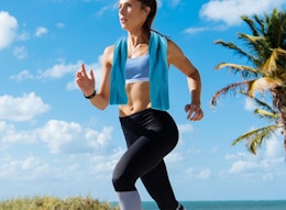 a woman running with a cooling towel outside
