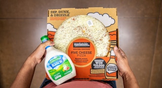Person holding a Walmart pizza and Hidden Valley Ranch Dressing