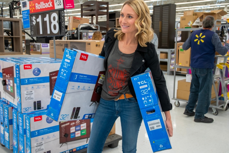 Person carrying two TVs in Walmart