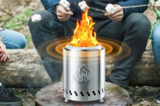 Lifestyle image of Auseo tabletop fire pit being used outdoors to roast marshmallows 