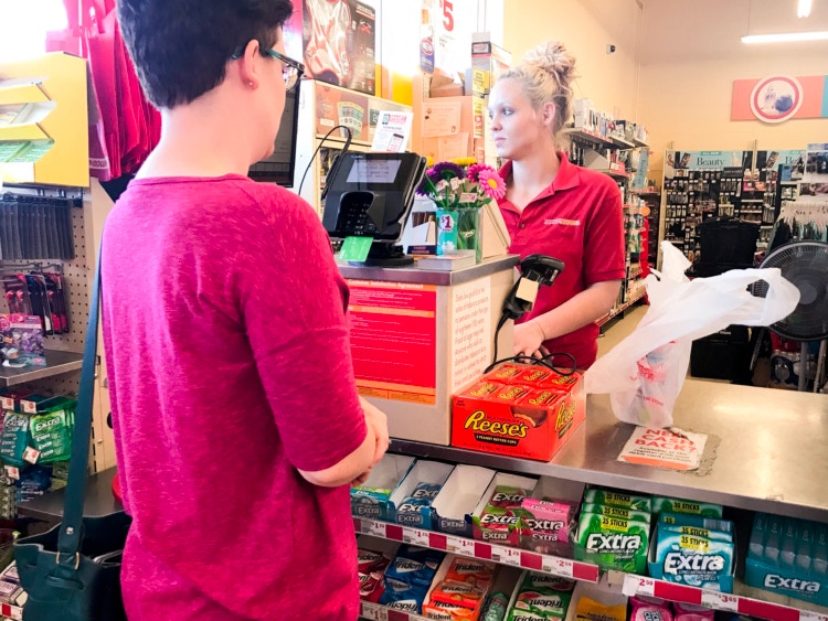 Employee assisting person checking out at Family Dollar