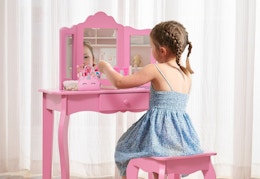 child sitting at a pink vanity set