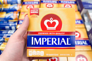 hand holding a pack of imperial butter