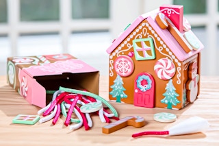 Lifestyle image of the Melissa & Doug Gingerbread Activity Set with contents spilled out of box next to a completed set