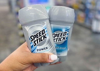 person holding two speed stick deodorants