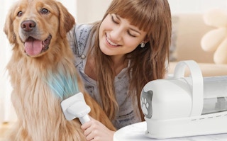 a woman using a pet groomer on a dog