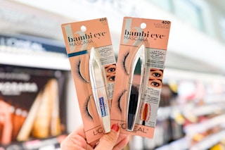 hand holding two mascaras in store beauty aisle