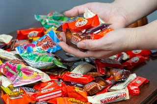 someone taking handfuls of candy from a huge pile