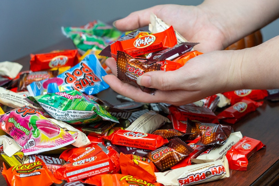 someone taking handfuls of candy from a huge pile