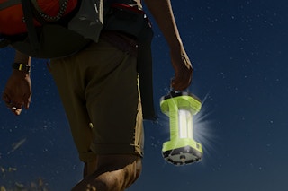 a man using a camping lantern