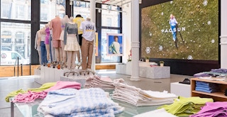 The inside of a PacSun store with clothing displayed on tables and mannequins
